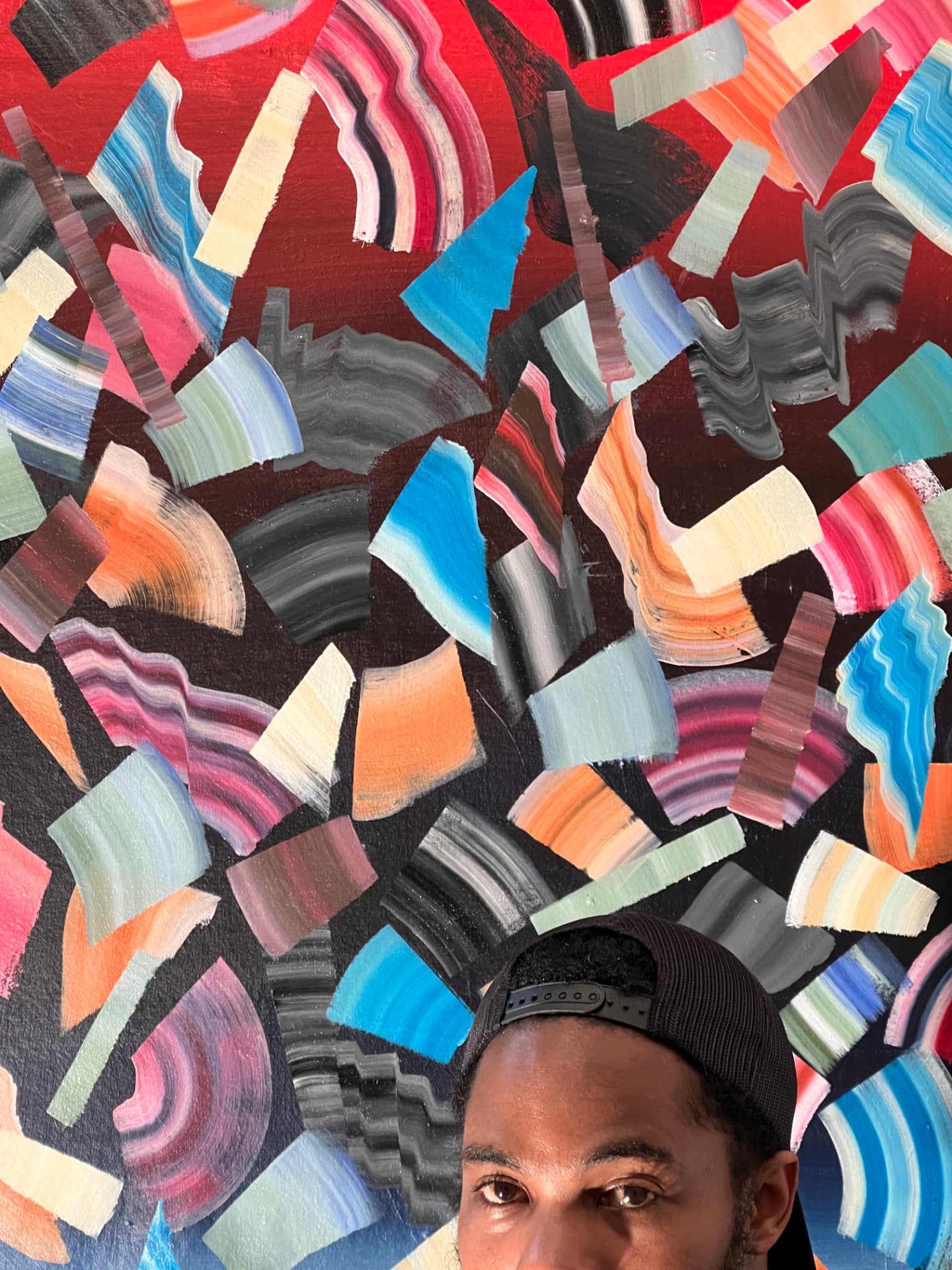 Kel Brown in front of one of his layered abstract paintings